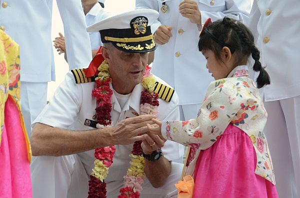 Sỹ quan chỉ huy tàu sân bay USS George Washington (CVN 73) tặng những đồng xu biểu tượng của USS George Washington (CVN 73) cho các em nhỏ Hàn Quốc trong lễ đón.